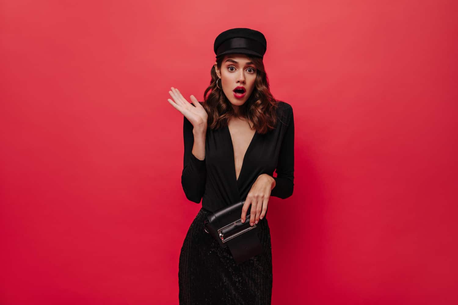 Shocked woman rises arms Elegant lady in black cap and festive dress