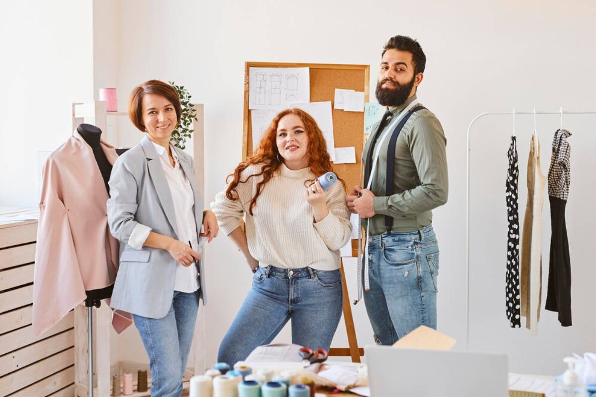 smiley fashion designers posing in their business atelier