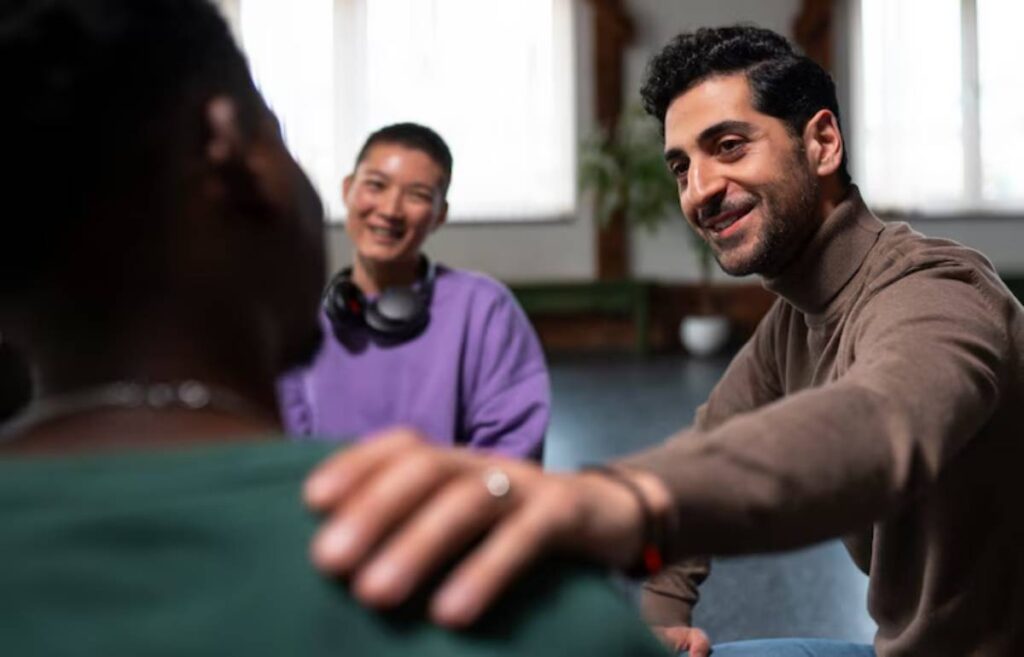 A group of people engages in a supportive conversation, focusing on empathy and connection