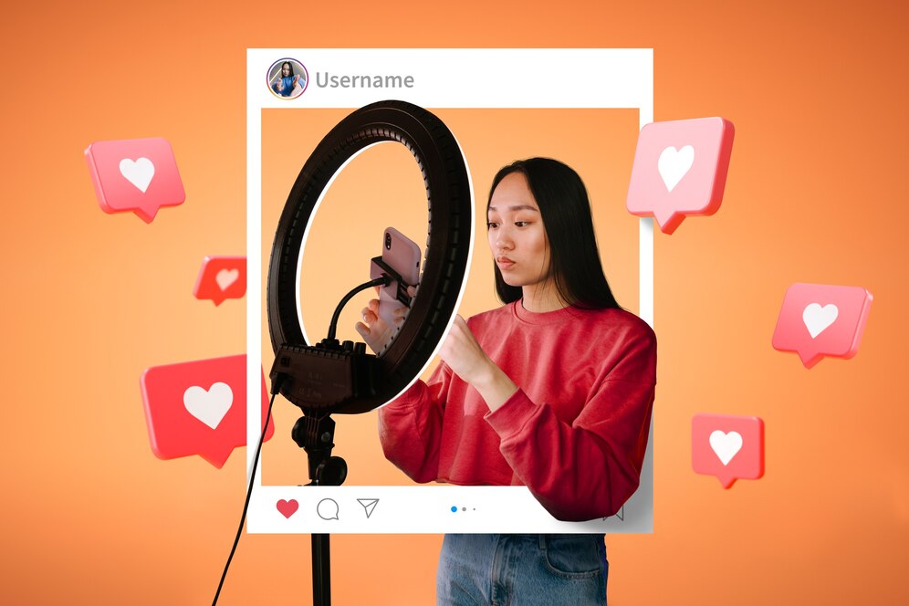 Young woman using a smartphone with a ring light, framed by a social media interface with heart icons, on an orange background.
