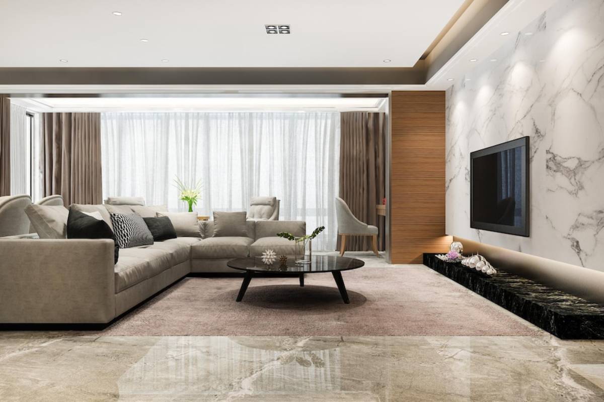 Luxurious living room with large sectional sofa, marble walls, wooden accents, and a glass-topped coffee table.